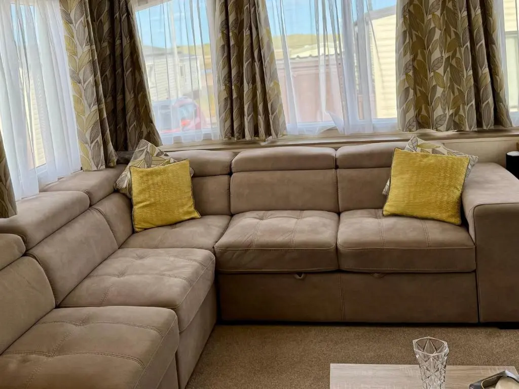 a brown couch with two yellow pillows on it at Sutherland C14 in Lossiemouth
