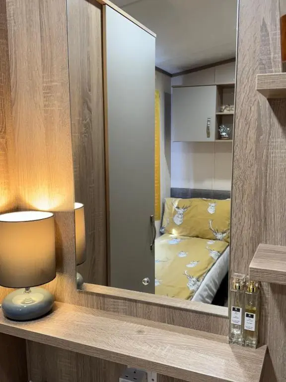 a mirror in a room with a bed in a bedroom at Sutherland C14 in Lossiemouth