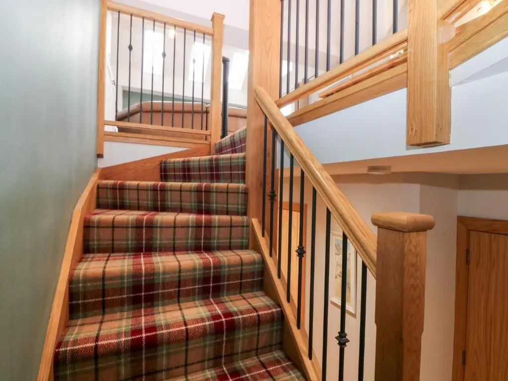 a set of stairs in a home with wooden railings at The Old Kipper Hoose in Banff