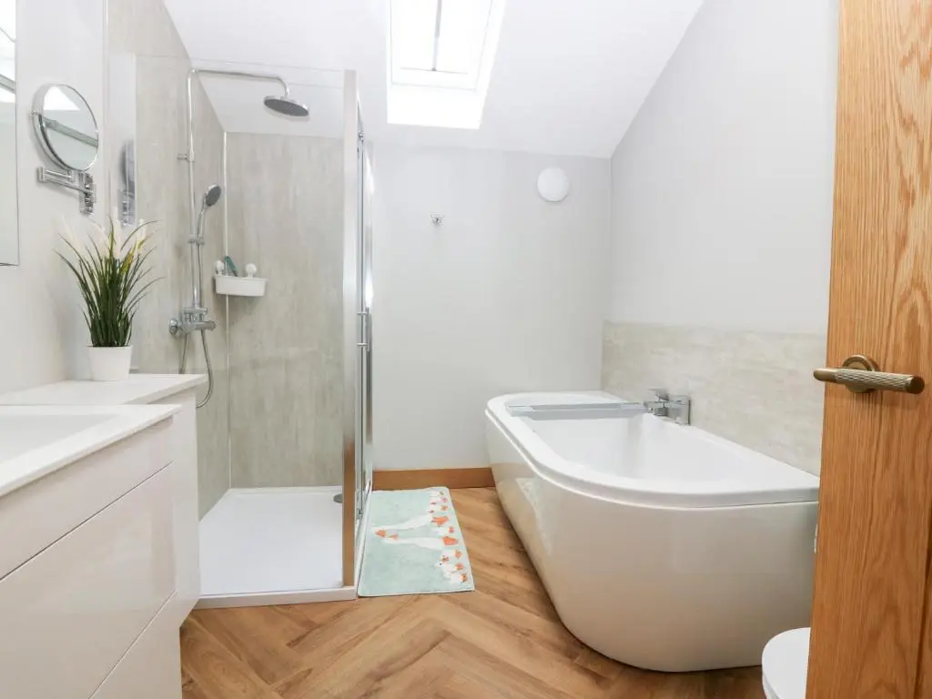 a bathroom with a tub and a toilet and a sink at The Old Kipper Hoose in Banff