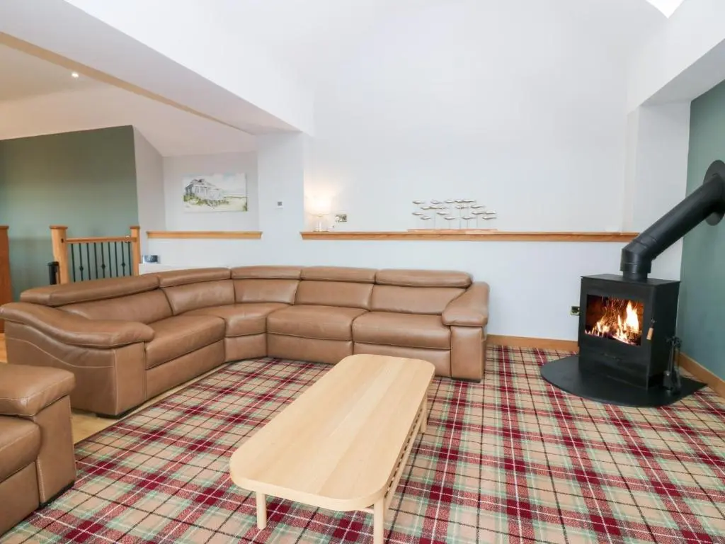 a living room with a couch and a fireplace at The Old Kipper Hoose in Banff