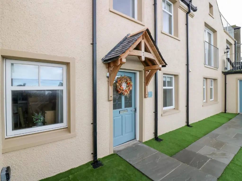 a house with a blue door and a wreath on it at The Old Kipper Hoose in Banff