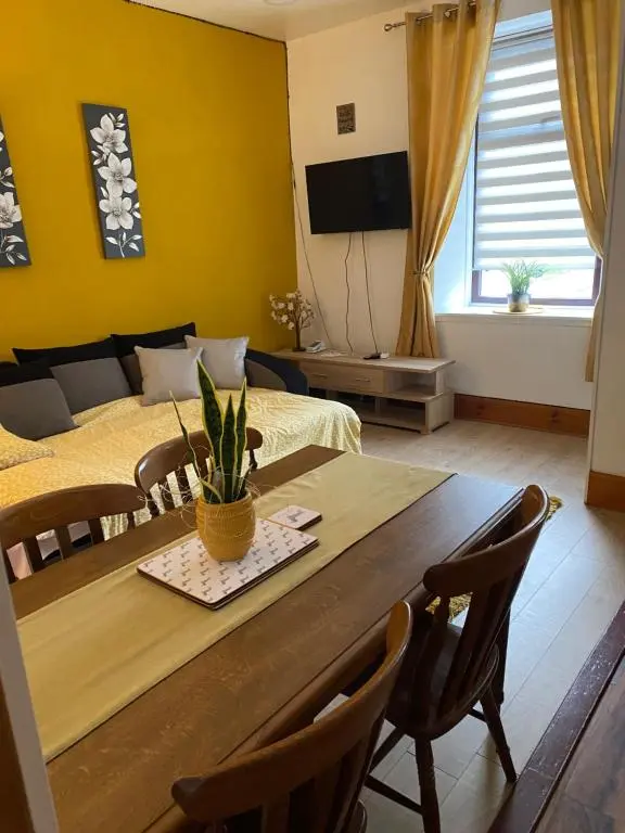 a living room with a dining table and a bedroom at Cozy one bedroom apt in Inverness