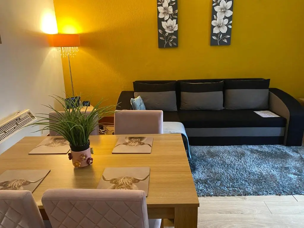 a living room with a table and a couch at Cozy one bedroom apt in Inverness