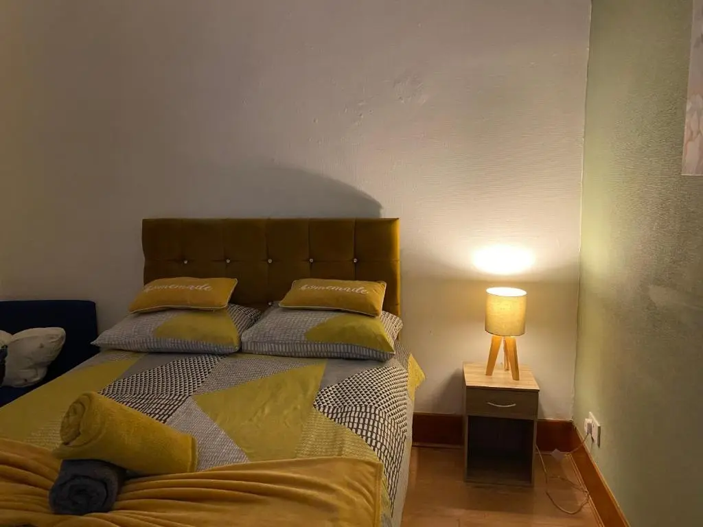 a bedroom with a bed with yellow pillows and a lamp at Cozy one bedroom apt in Inverness