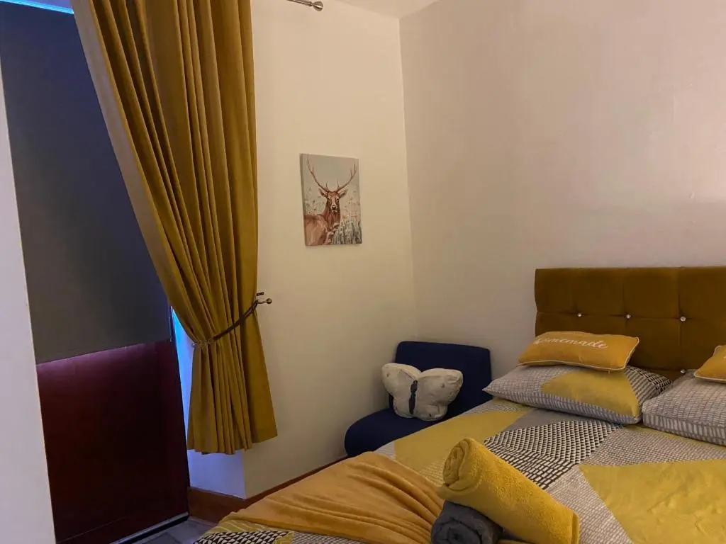 a bedroom with a bed and a yellow curtain at Cozy one bedroom apt in Inverness