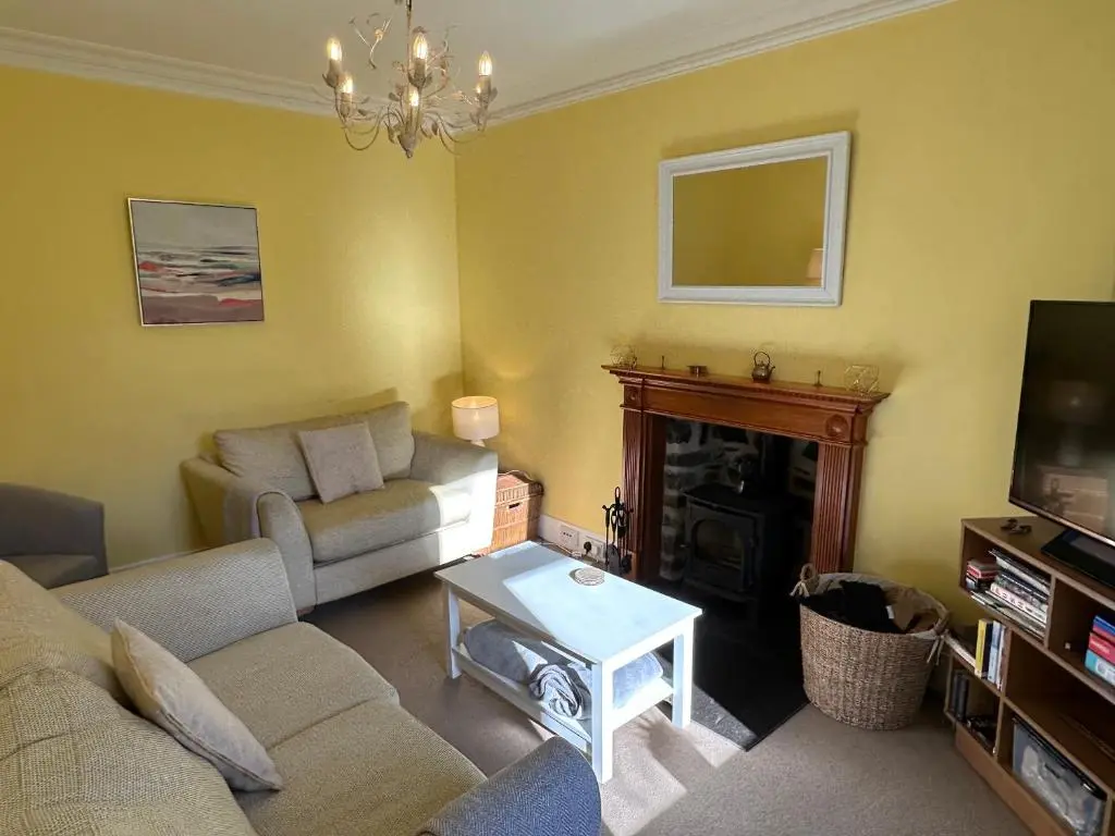 a living room with a couch and a fireplace at Cosy Cottage on the Whisky Trail in Haugh of Glass