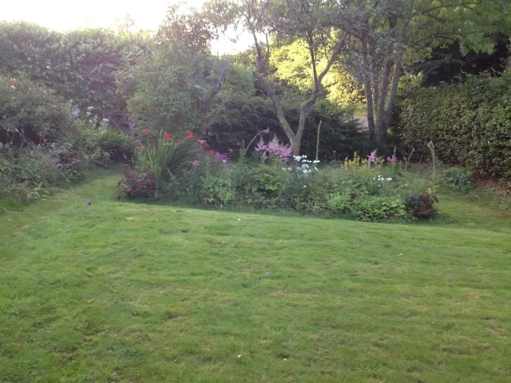 a yard with a garden with flowers and plants at Charming cottage close to the Cairngorms in Ballindalloch