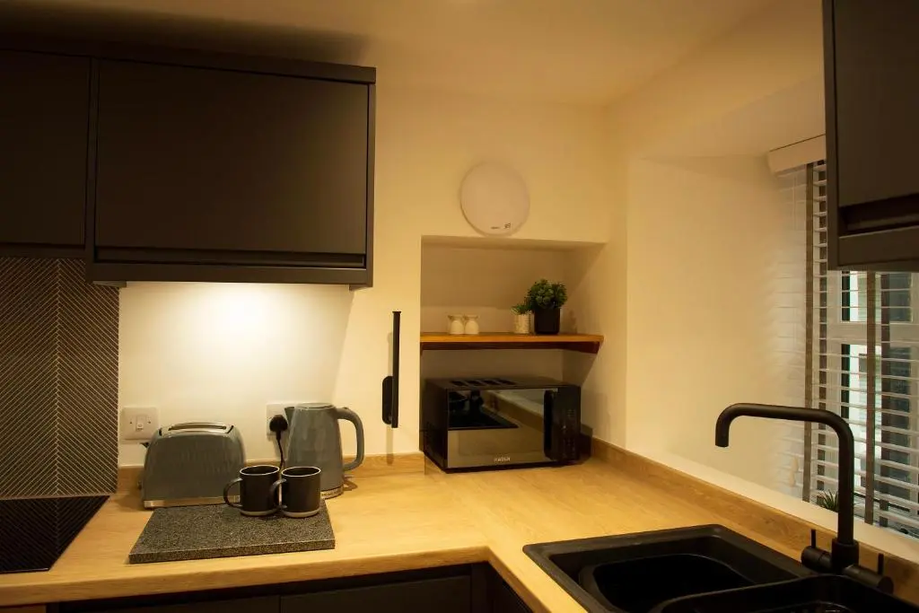 a kitchen with a sink and a microwave at Coorie-In Cottage in Whitehills