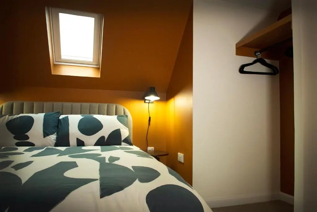 a bedroom with a bed and a window on the wall at Coorie-In Cottage in Whitehills