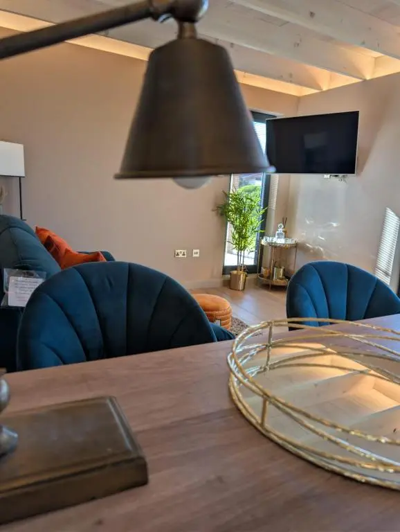 a dining room table with blue chairs and aendant light at Luxury Lodge by Findhorn Sands No 18 in Findhorn