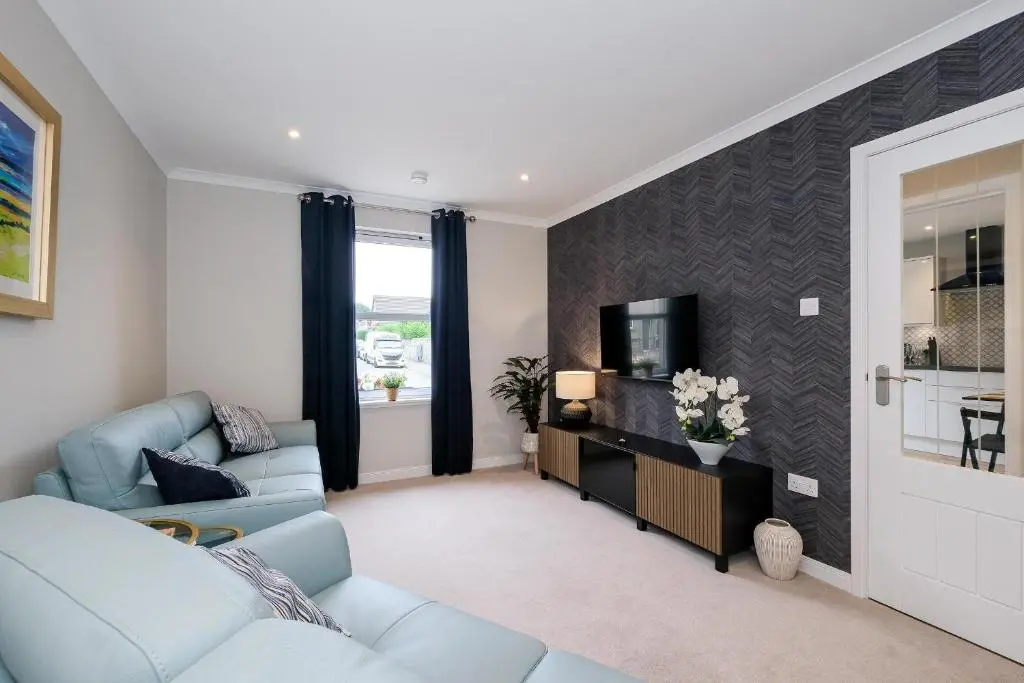a living room with a couch and a tv at High Street Retreat in Inverurie