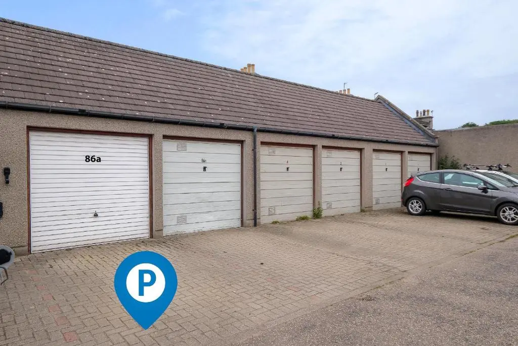 a row of garage doors with a car parked in front at High Street Retreat in Inverurie