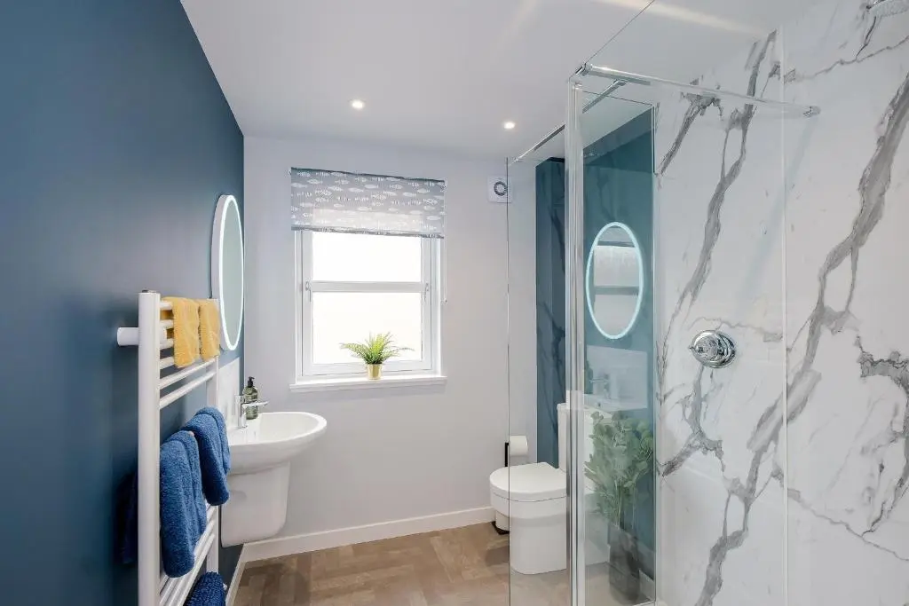 a bathroom with a shower and a toilet and a sink at High Street Retreat in Inverurie