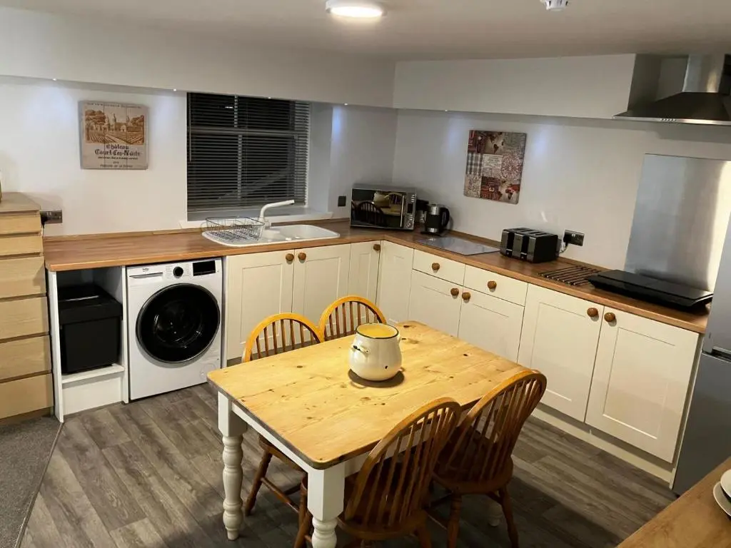 a kitchen with a table and chairs and a sink at The Bunker Self Catering in Nairn