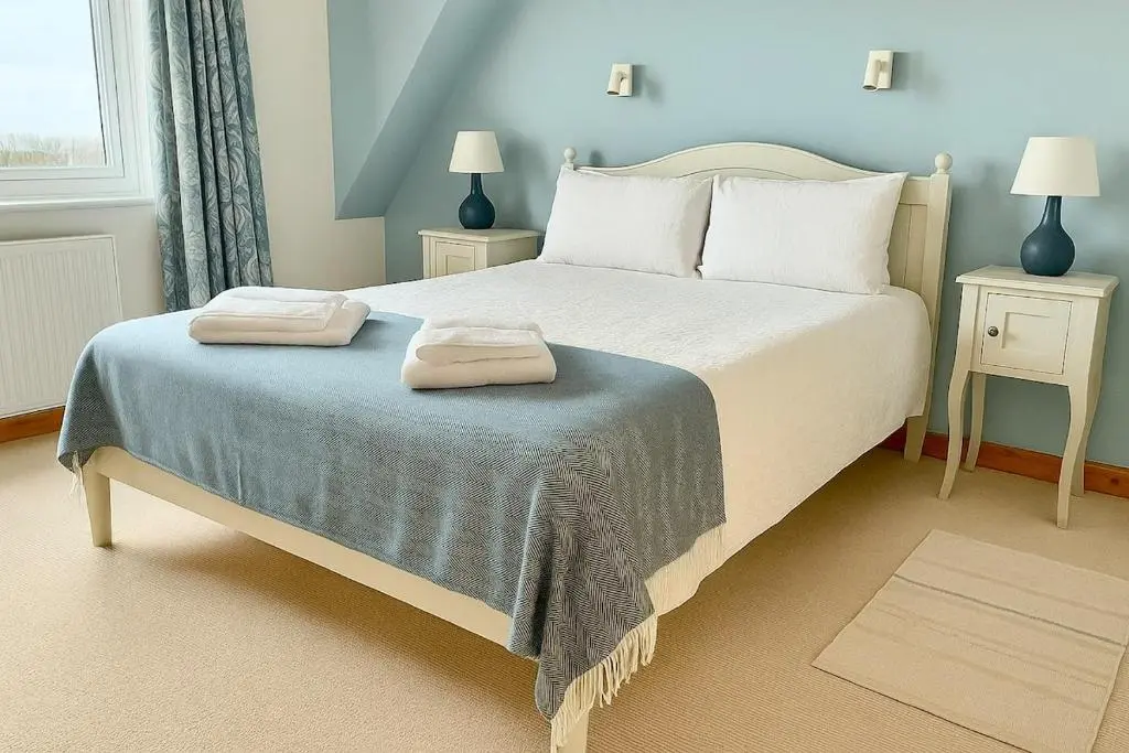 a bedroom with a bed with two towels on it at Beachy Days and Family Stays in Nairn
