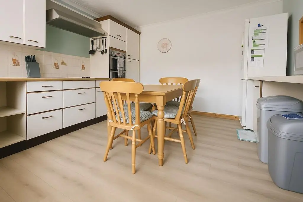 a kitchen with a wooden table and two chairs at Beachy Days and Family Stays in Nairn