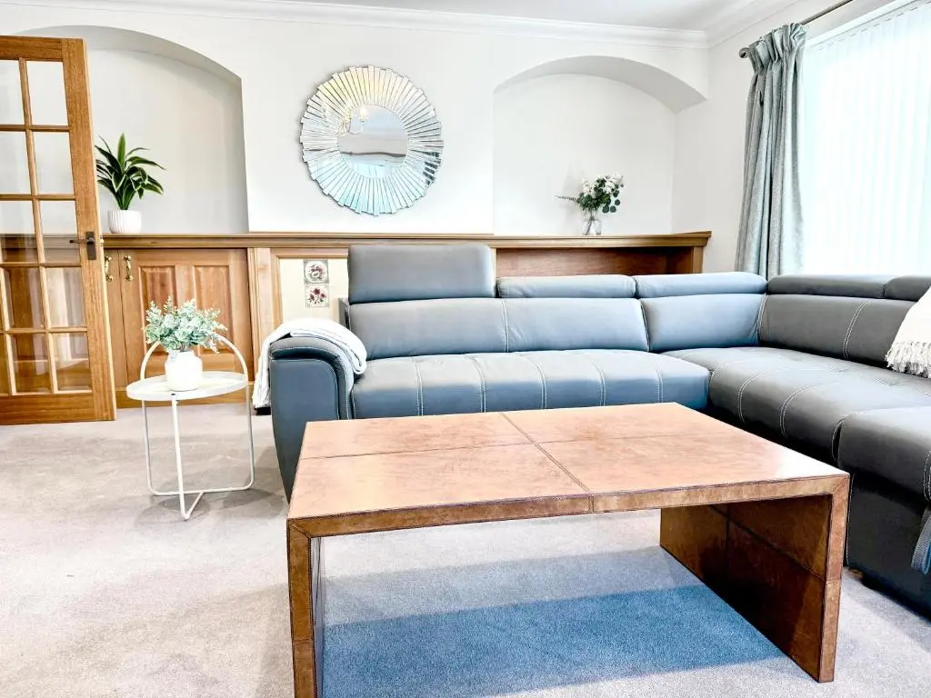 a living room with a blue couch and a table at Golf View Spacious Bungalow 2 Bathrooms, Free Parking WiFi in Elgin