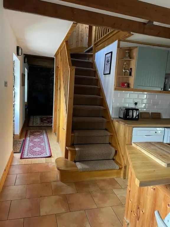 a staircase leading up to the kitchen of a tiny house at Culrain Cottage in Fort Augustus
