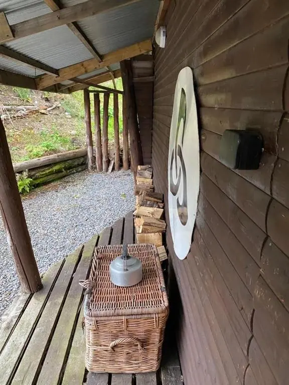 a wooden porch with a table and a pot on it at Culrain Cottage in Fort Augustus