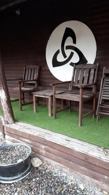 two chairs sitting on a porch with a surfboard at Culrain Cottage in Fort Augustus