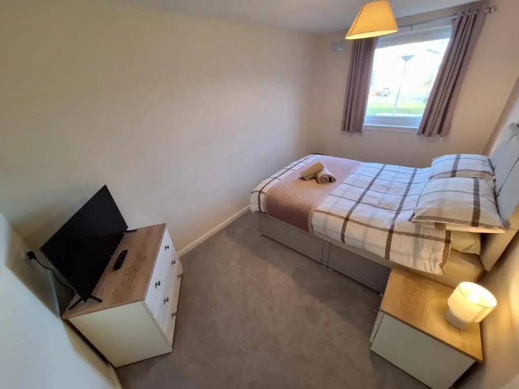a small bedroom with a bed and a television at Spacious Two Bed Close To City Centre!! in Dalneigh