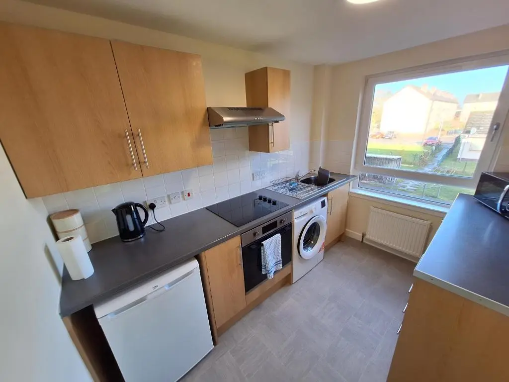 a small kitchen with a washer and dryer in it at Spacious Two Bed Close To City Centre!! in Dalneigh