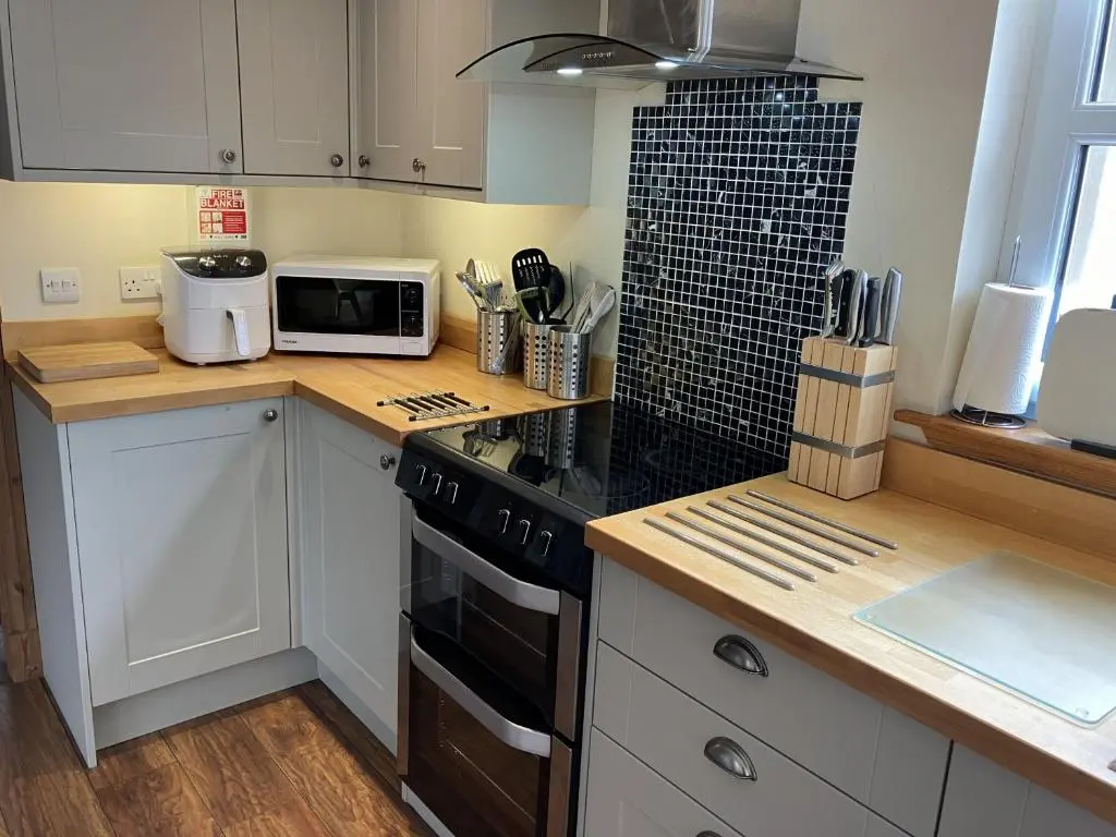 a kitchen with a counter top with a stove and a microwave at Oiseval in Fort Augustus