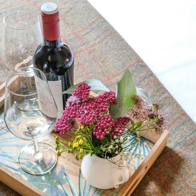 a wooden tray with a bottle of wine and flowers at Beautiful dog friendly lodge with hot tub in Aboyne