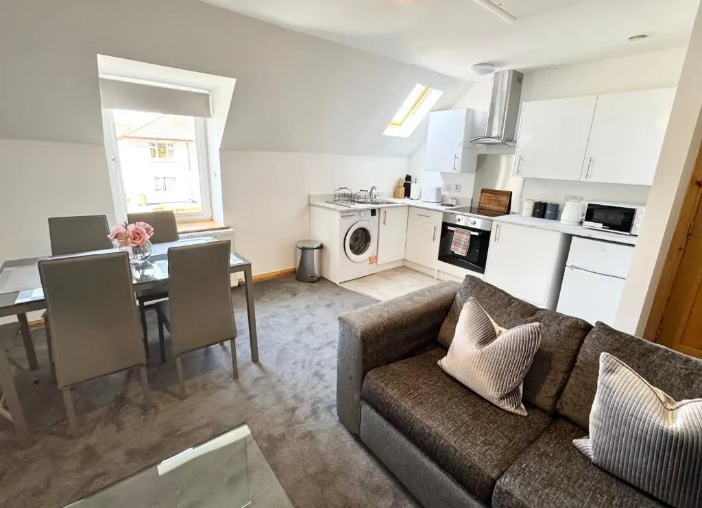 a living room and kitchen with a couch and a table at Suites Holiday Home Inverness in Inverness