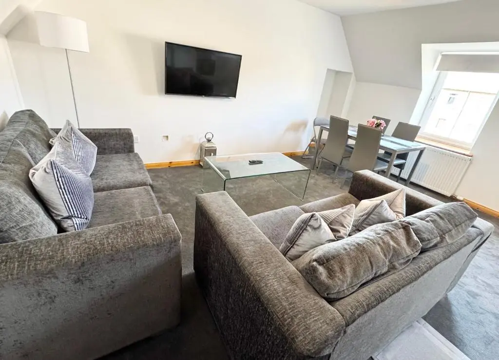 a living room with two couches and a tv at Suites Holiday Home Inverness in Inverness