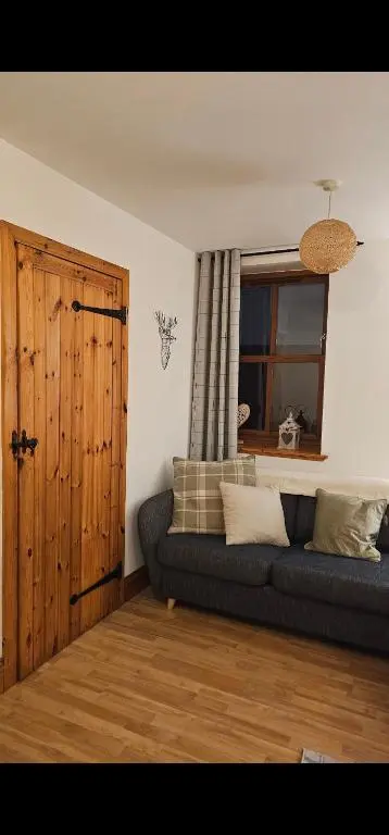 a living room with a couch and a window at The Saddlery Inverness in Dalneigh