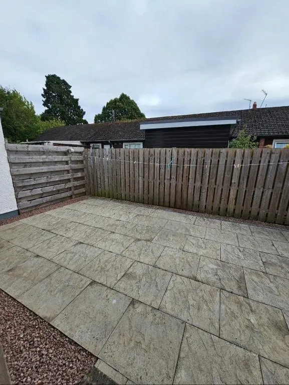a patio in front of a wooden fence at The Saddlery Inverness in Dalneigh
