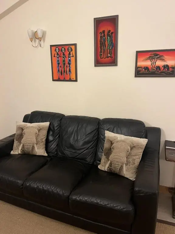 a black leather couch sitting in a living room at Hopeman Cottages in Hopeman