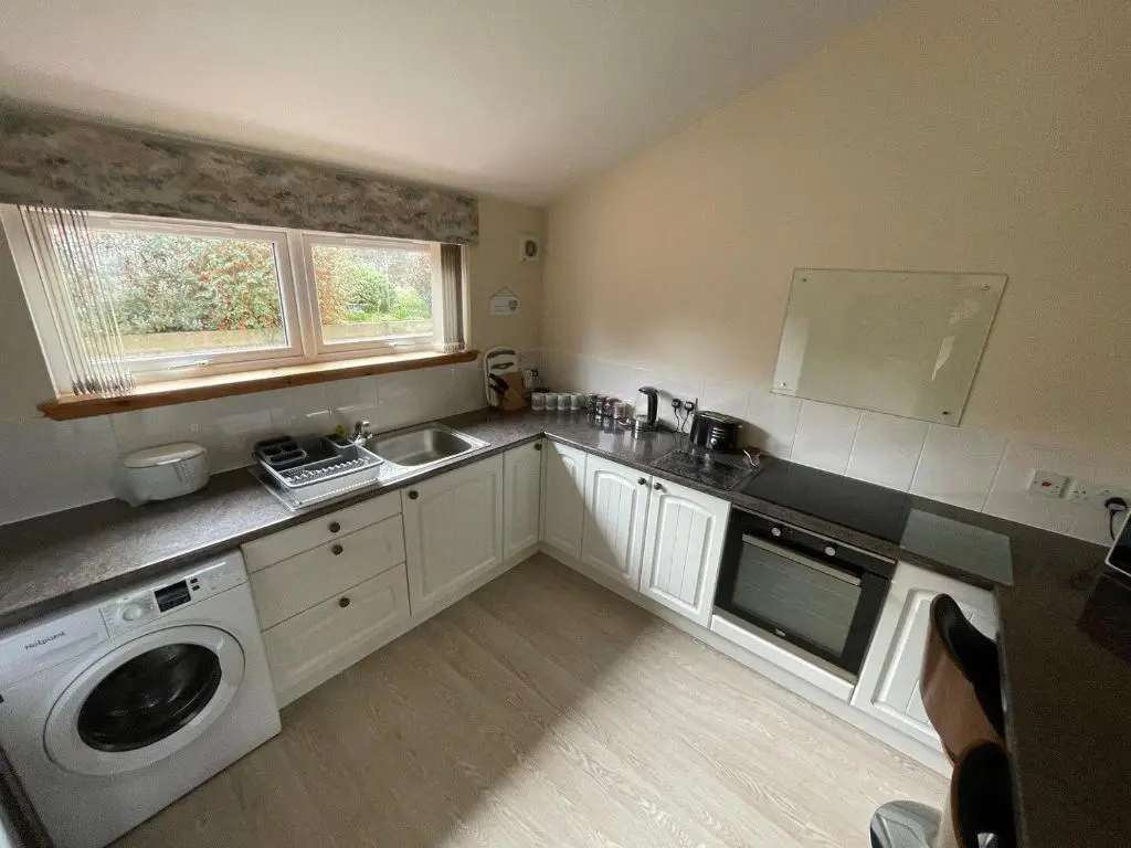 a kitchen with a sink and a washing machine at Hopeman Cottages in Hopeman