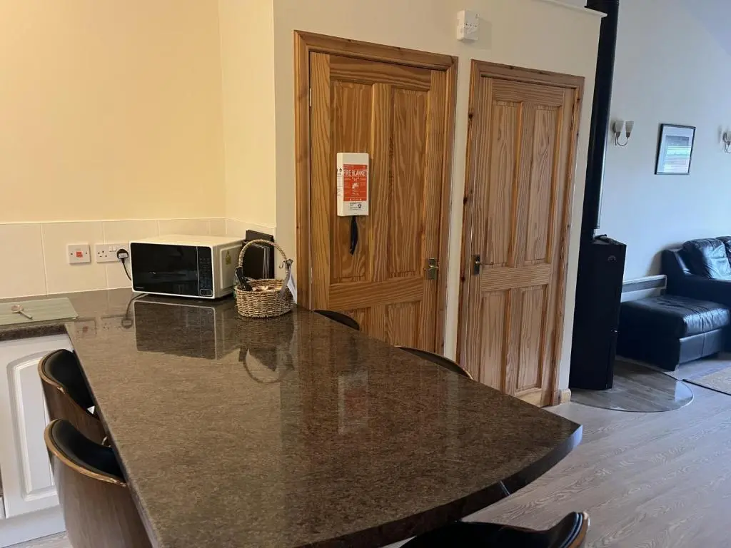 a kitchen with a counter with a table with a microwave at Hopeman Cottages in Hopeman