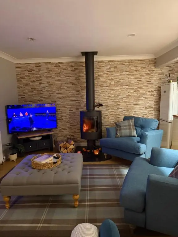 a living room with blue furniture and a fireplace at Culloden retreat in Culloden