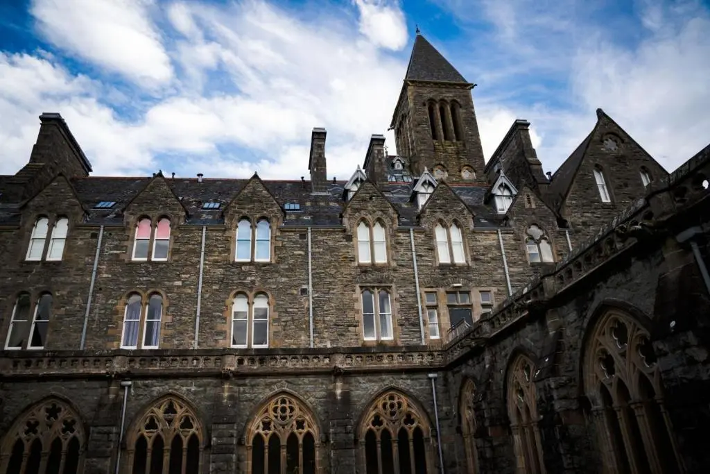 a large brick building with a clock tower at Moat House 6 in Fort Augustus