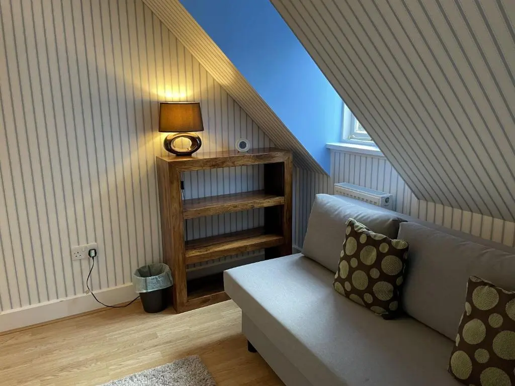 a living room with a couch and a lamp at Moat House 6 in Fort Augustus