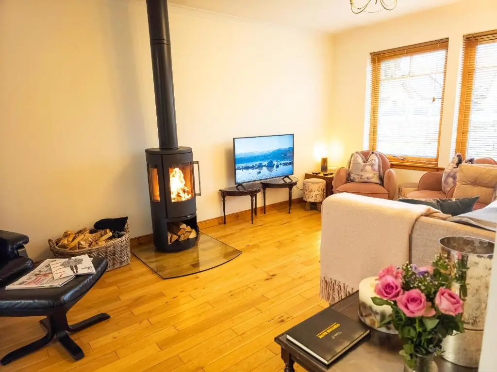 a living room with a fireplace and a couch at Casa Amor in Aviemore