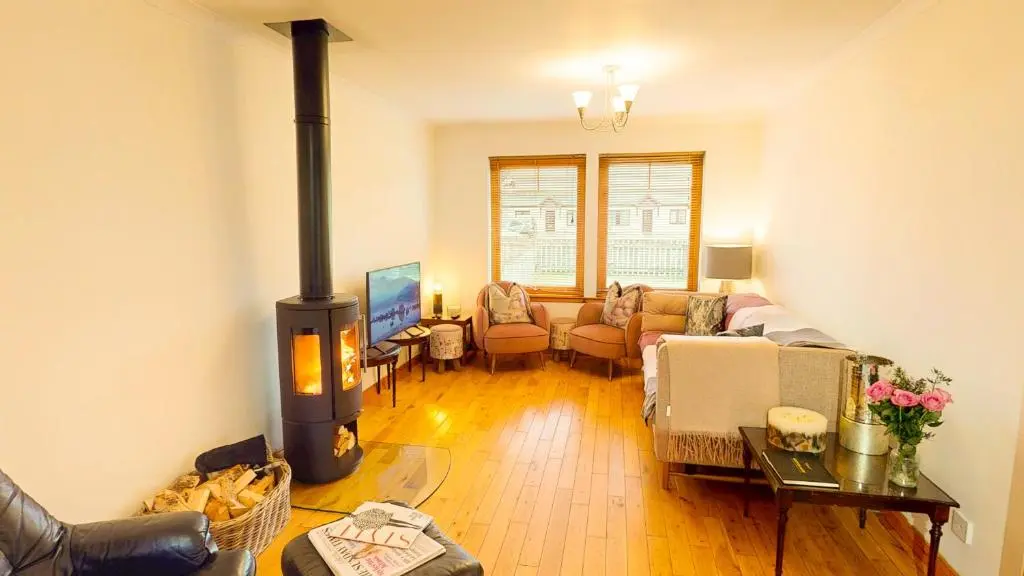a living room with a wood burning stove in it at Casa Amor in Aviemore