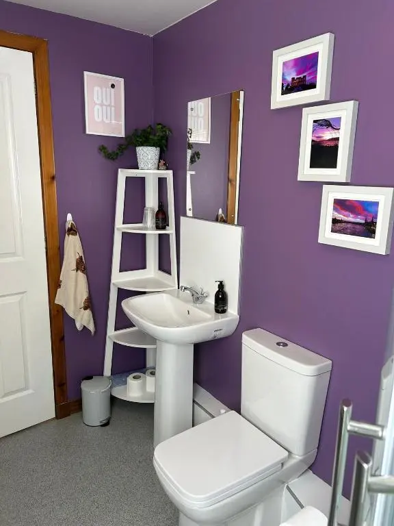 a purple bathroom with a toilet and a sink at Cosy 1 bedroom ground floor flat, Central Inverness in Inverness