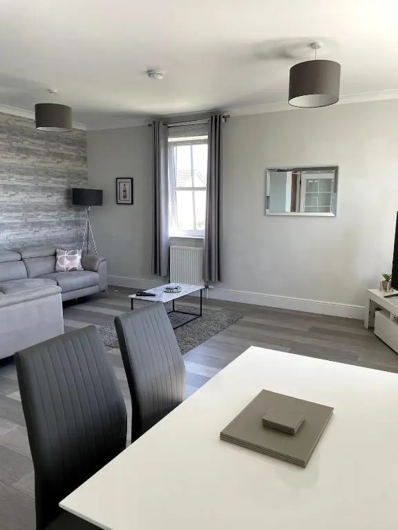 a living room with a table and a couch at Spacious Flat in Aberdeenshire in Insch