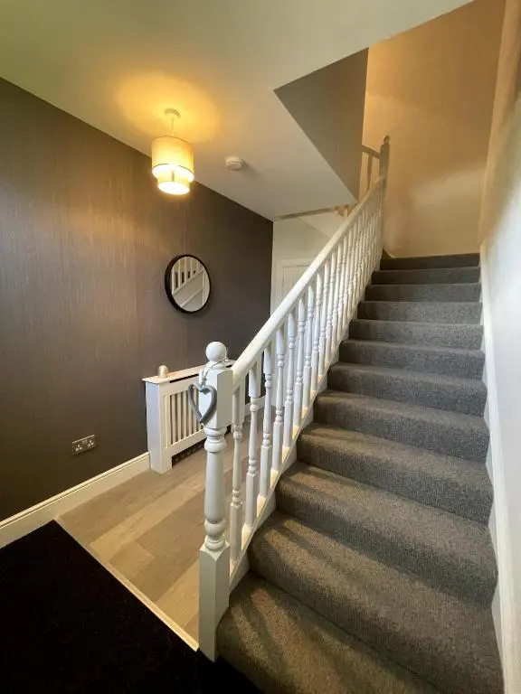 a staircase in a home with a white stair case at Spacious Flat in Aberdeenshire in Insch