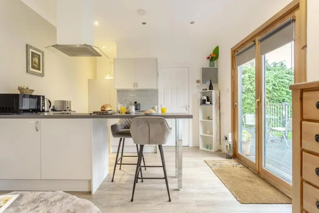 a kitchen with white cabinets and a counter with chairs at 1 Bed in Inverness oc-a33726 in Inverness