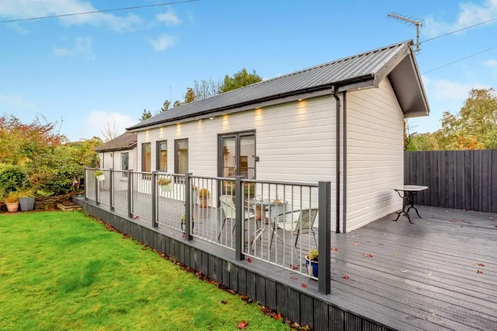 a small white house with a deck at 1 Bed in Inverness oc-a33726 in Inverness
