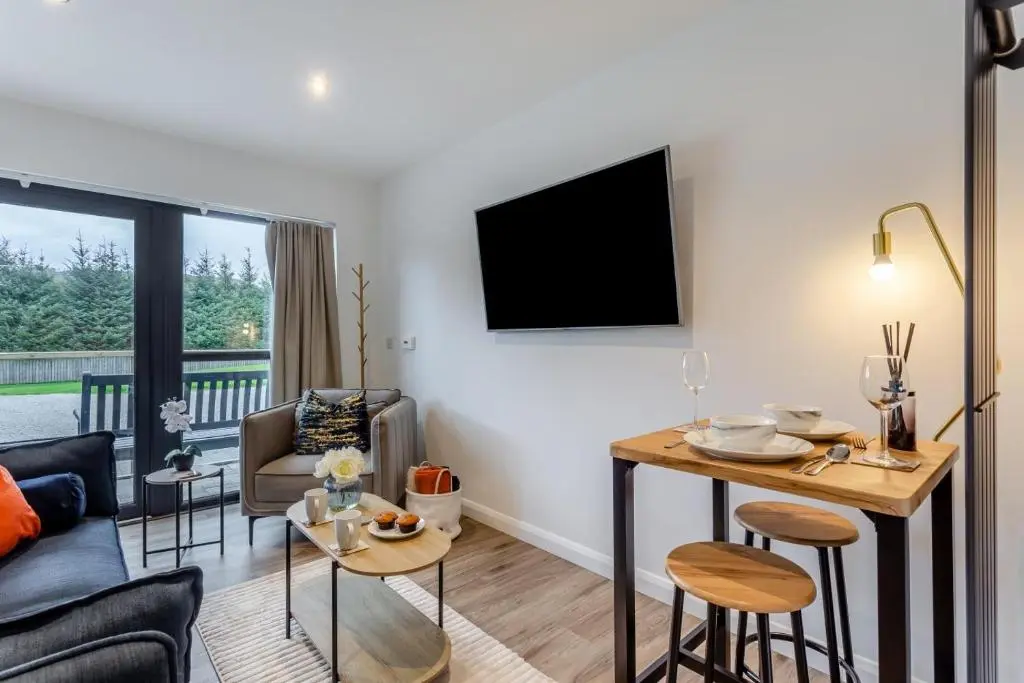 a living room with a couch and a table with chairs at 1 Bed in Daviot oc-c33520 in Daviot