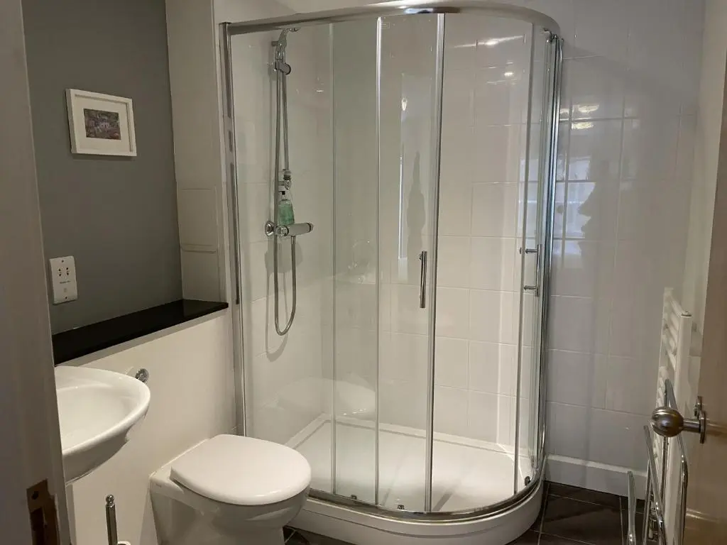 a bathroom with a shower with a toilet and a sink at Raven Wing 11 - Kintail Apartment in Fort Augustus