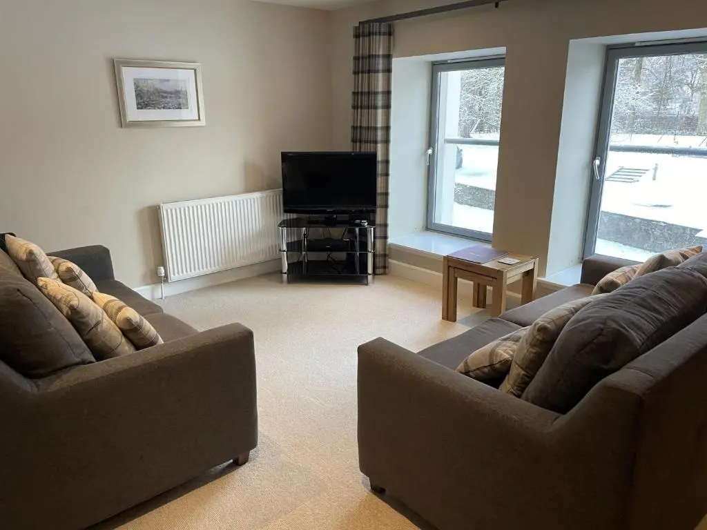 a living room with two couches and a television at Raven Wing 11 - Kintail Apartment in Fort Augustus