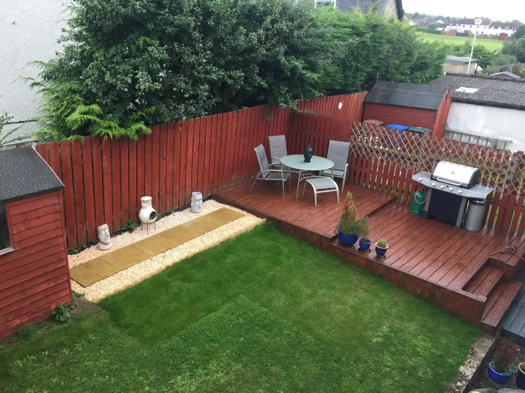 a small backyard with a table and a fence at 26 Two bedroom apt with private garden in Culloden